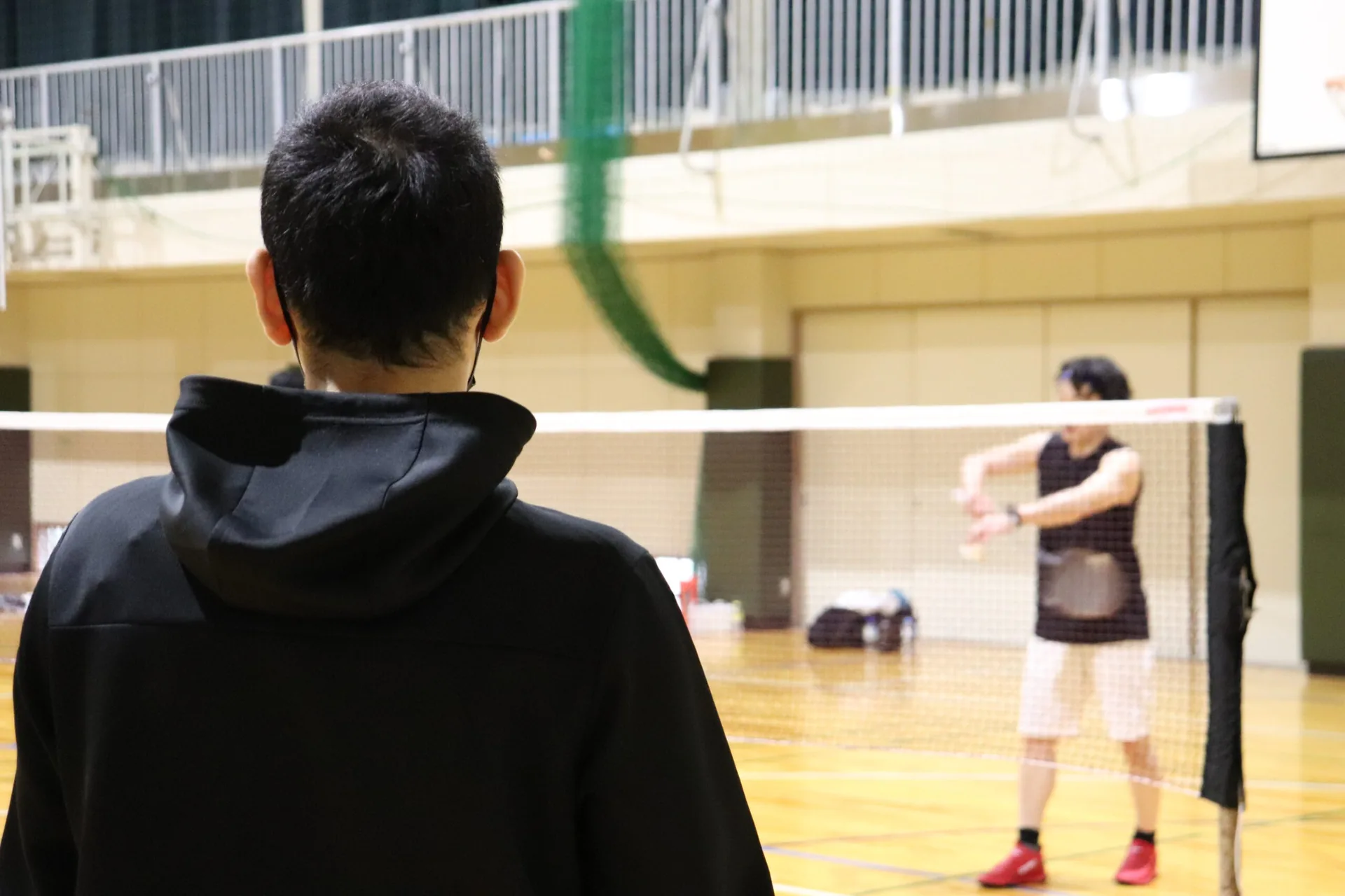 コート越しにラリー練習をする様子