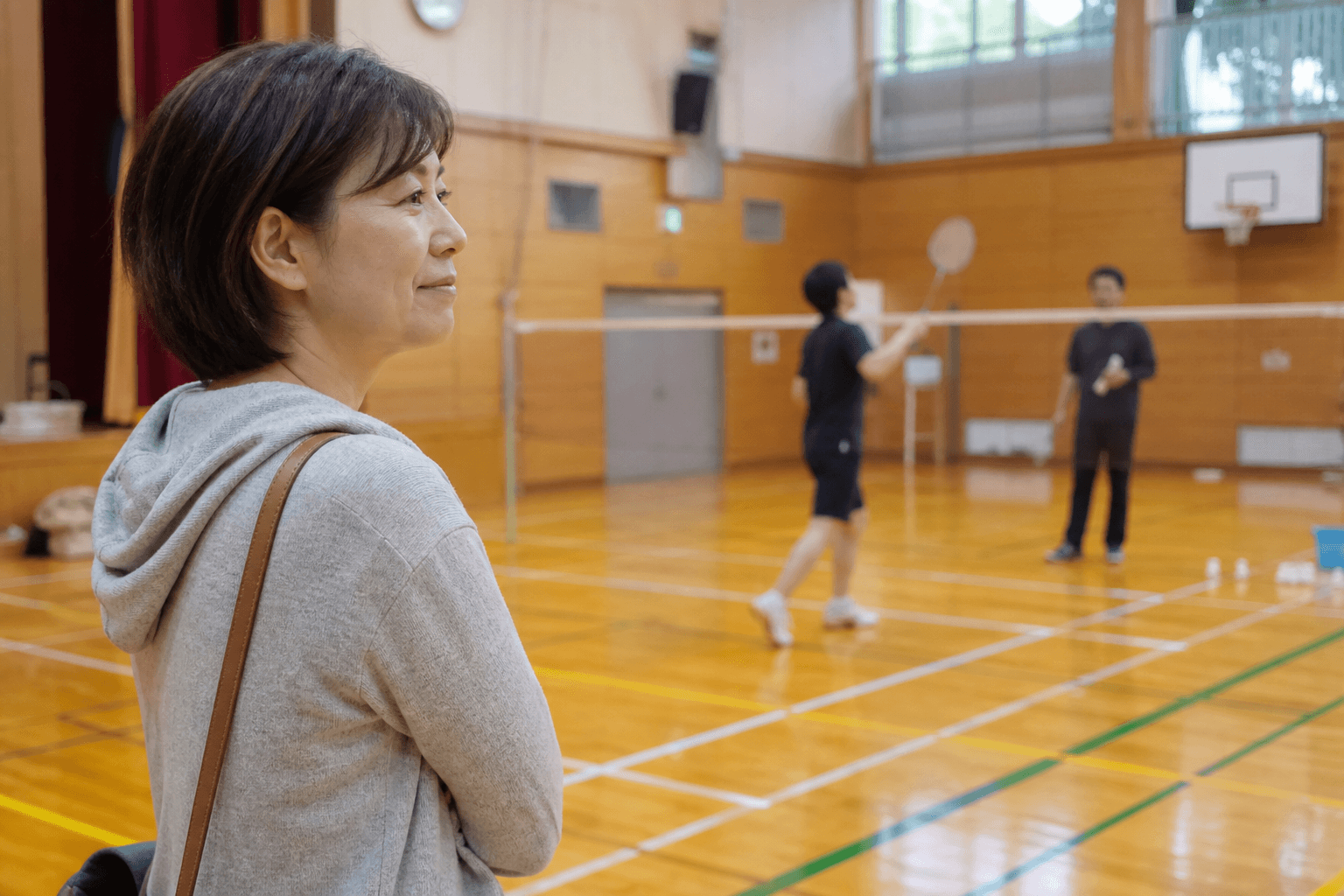 体育館で子どもの練習を見守る保護者